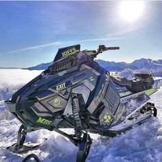 a snowmobile is parked in the snow on a sunny day