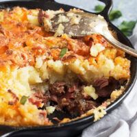 a close up of a casserole dish with meat and vegetables in it on a table