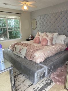 a bedroom with a large bed and pink pillows