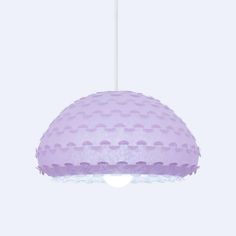 a purple light hanging from a white ceiling fixture with polka dots on the fabric covering