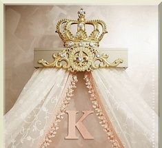 there is a gold crown on top of the letter k hanging from a cross that has been draped over it