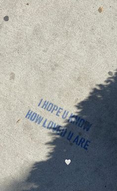 someone's feet are standing on the sidewalk with words written in blue and white