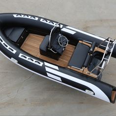 an inflatable boat is on the ground with its seat folded up and steering wheel down