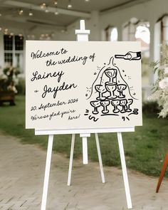 a welcome sign in front of a building with flowers and greenery on the lawn