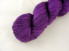 a skein of purple yarn sitting on top of a white surface