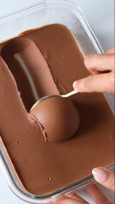 a person scooping chocolate into a container