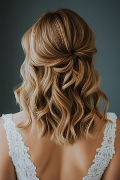 the back of a woman's head with wavy blonde hair and an intricate braid