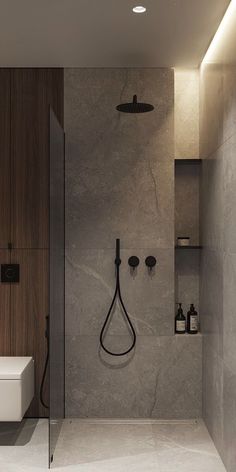 a bathroom with a walk in shower next to a white toilet and wooden wall shelves