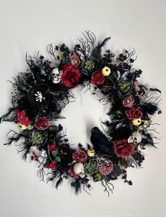 a wreath with flowers and skulls on it