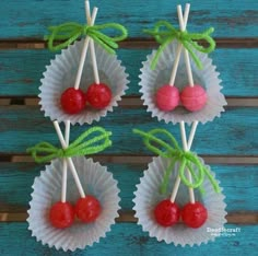 four cherries are sitting on top of paper plates