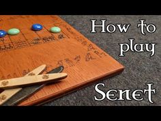 a wooden board with buttons on it and scissors next to it that says how to play the game