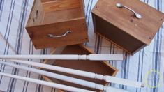 four wooden boxes with white handles on a bed