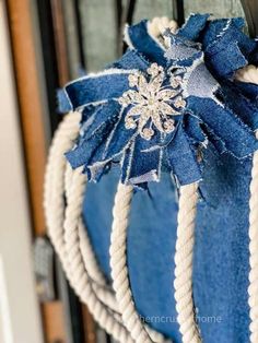 a blue and white bag hanging on the side of a wooden door with rope wrapped around it