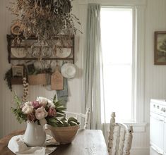 a wooden table topped with a bowl of flowers next to a white stove top oven