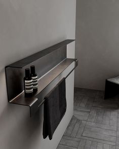 two black and white vases are sitting on a shelf in the corner of a bathroom