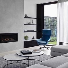 a living room with a couch, chair and fire place in the middle of it