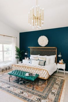 a bed room with a neatly made bed and a chandelier hanging from the ceiling