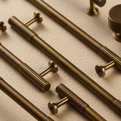 an assortment of brass hardware and knobs on a white surface