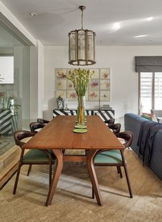 a dining room table with chairs and a couch in the back ground, next to a living room