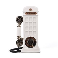 an old fashioned phone is sitting on a white stand with a telephone cord attached to it