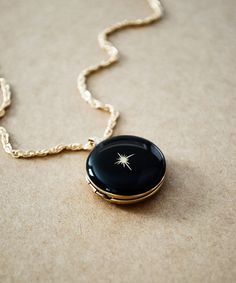 The North Star is an anchor, holding nearly still while the entire northern sky moves around it. This Gold Filled locket is a beautiful reminder, and can hold close what serves as your anchor, your ever constant guide through this life. Enameled in the color of your choice. (Sample shown in Black #28) ITEM DETAILS * Large round 14K Gold Filled locket measures 20 mm * Enameled in the color of your choice * Gold North Star detailed on the front of locket * Photo inserts on both inside areas of the Luxury Antique Round Locket Necklace, Black Compass Design Jewelry Gift, Star Locket, Star Photo, The North Star, Magical Jewelry, Photo Locket, Jewelry Lookbook, Fantasy Jewelry