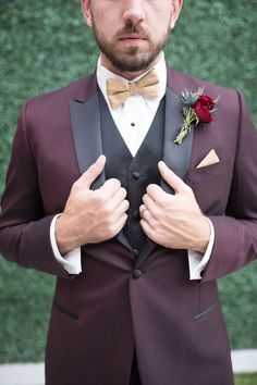 a man in a tuxedo is adjusting his bow tie