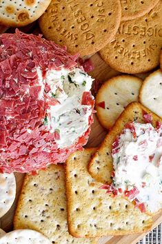 crackers and cheese are arranged on a wooden platter