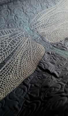 a close up view of a quilted bed with an intricate design on the side