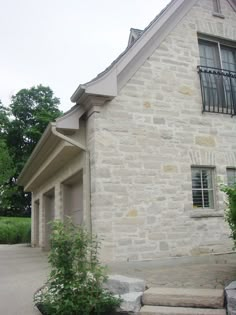 an old stone house with steps leading up to the front door and side entrance area