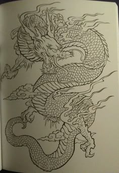 an open book with a drawing of a dragon on it