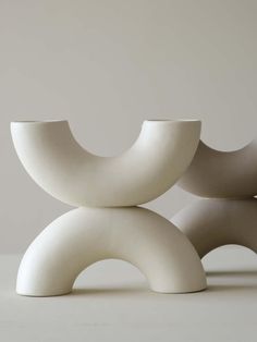 two white vases sitting next to each other on a table