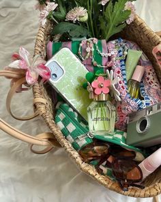 a basket filled with lots of items on top of a white bed cover covered in pink flowers