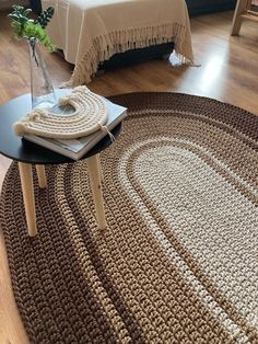 a living room with a round rug on the floor and a bed in the background