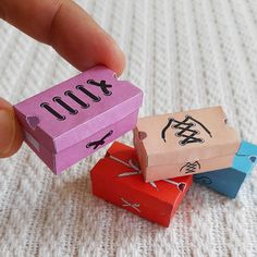 three small boxes with numbers on them being held by a hand