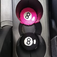 two black and pink balls sitting on top of each other in the back of a car