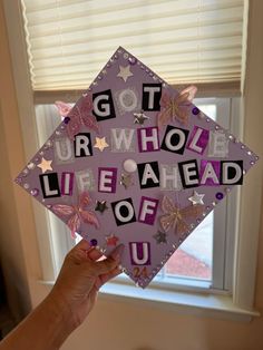 someone holding up a purple graduation cap that says got your whole life ahead of you