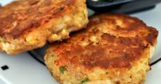 two crab cakes sitting on top of a white plate