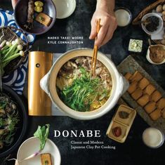 a person holding chopsticks over a bowl of food on top of a table