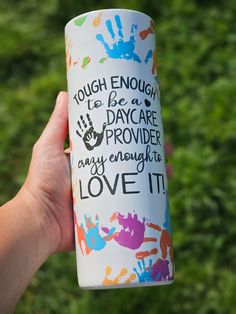 a person holding up a coffee cup that says tough enough to be a day care worker may enough love it