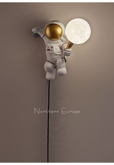 an astronaut lamp with the moon behind it