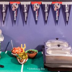 some food is sitting on a table with flags hanging from the wall behind it and two bowls of fruit in front of them