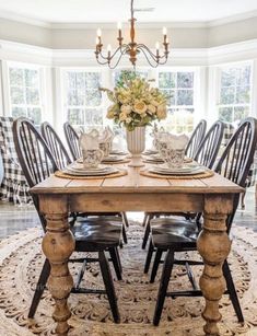 a dining room table with chairs and a rug on the floor in front of it