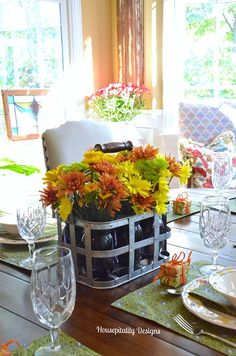 a dining room table set with flowers in a basket