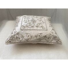 a white pillow with an embroidered design on it