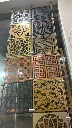 an assortment of decorative panels on display in a glass case with metal handles and sides