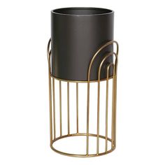 a black and gold metal planter with two handles on it's sides, in front of a white background