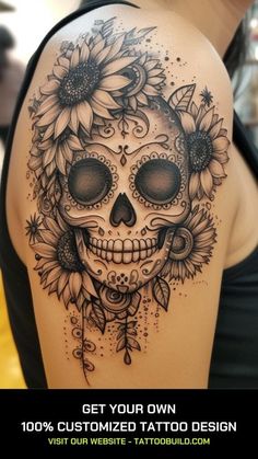 a woman's shoulder with sunflowers and a skull tattoo on the side