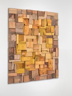 a wooden wall hanging on the side of a white wall covered in wood planks