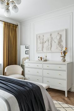 a bedroom with white furniture and gold drapes