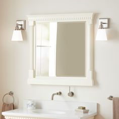 a white bathroom sink sitting under a mirror